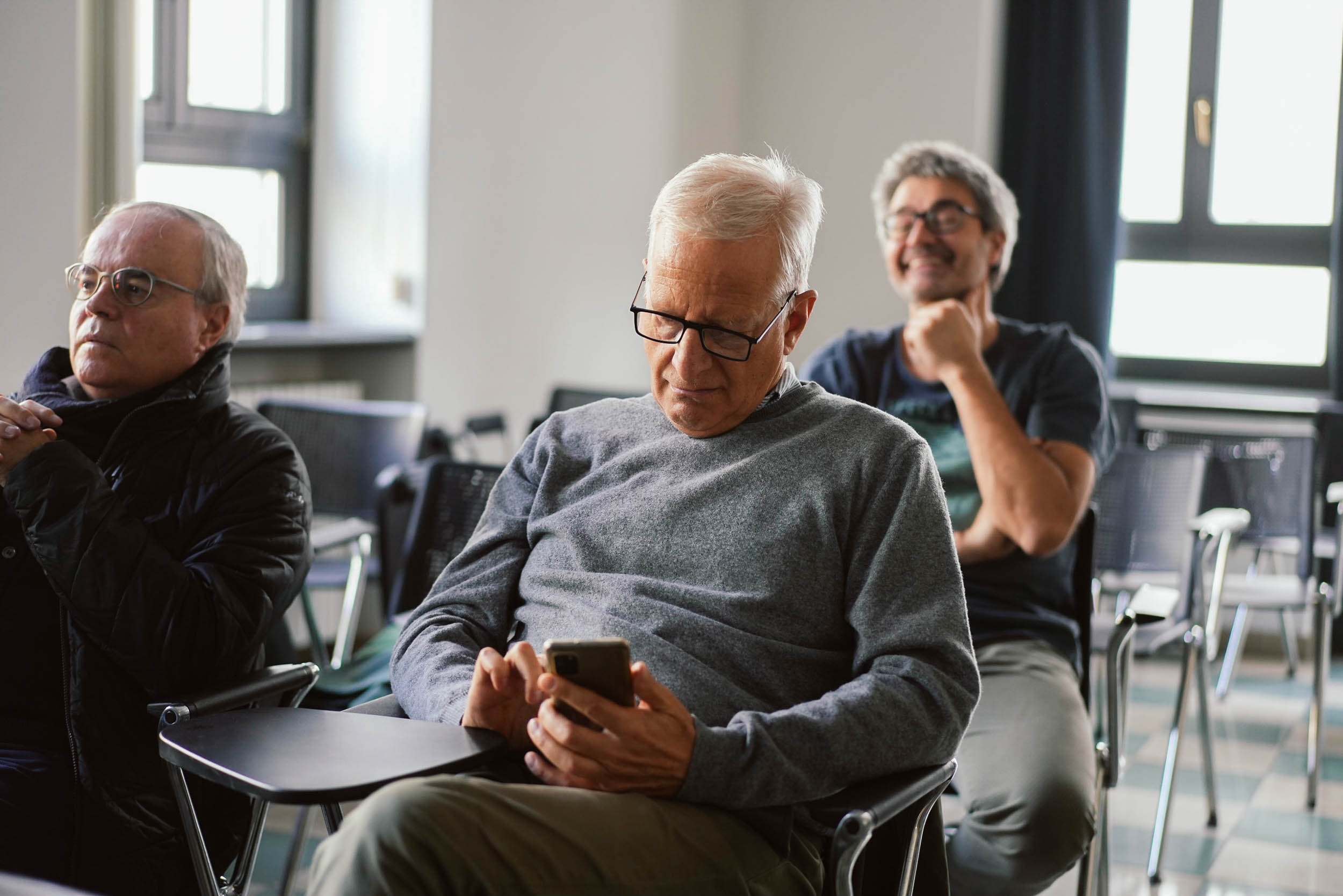 Volontari aiutano un gruppo di persone senior con lo smartphone